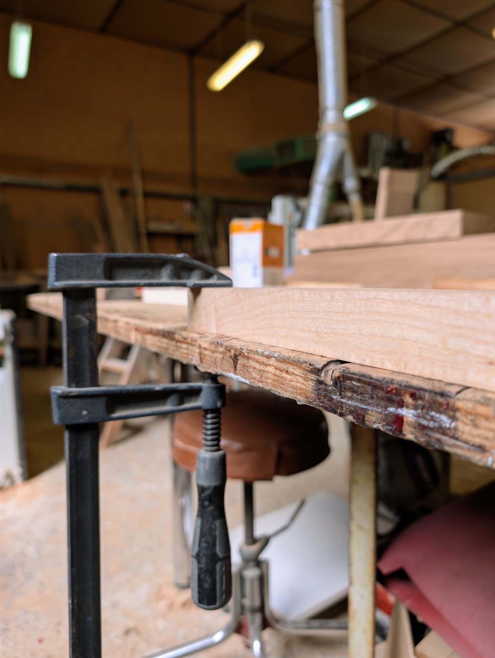 Plateau de bois maintenu par des serre-joints pendant le collage